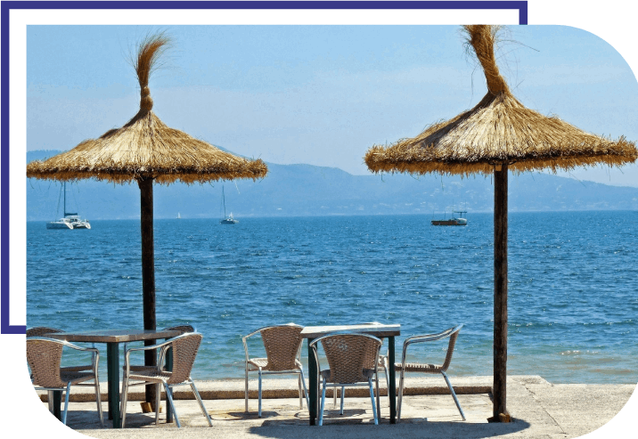 A beach with chairs and umbrellas on the sand.