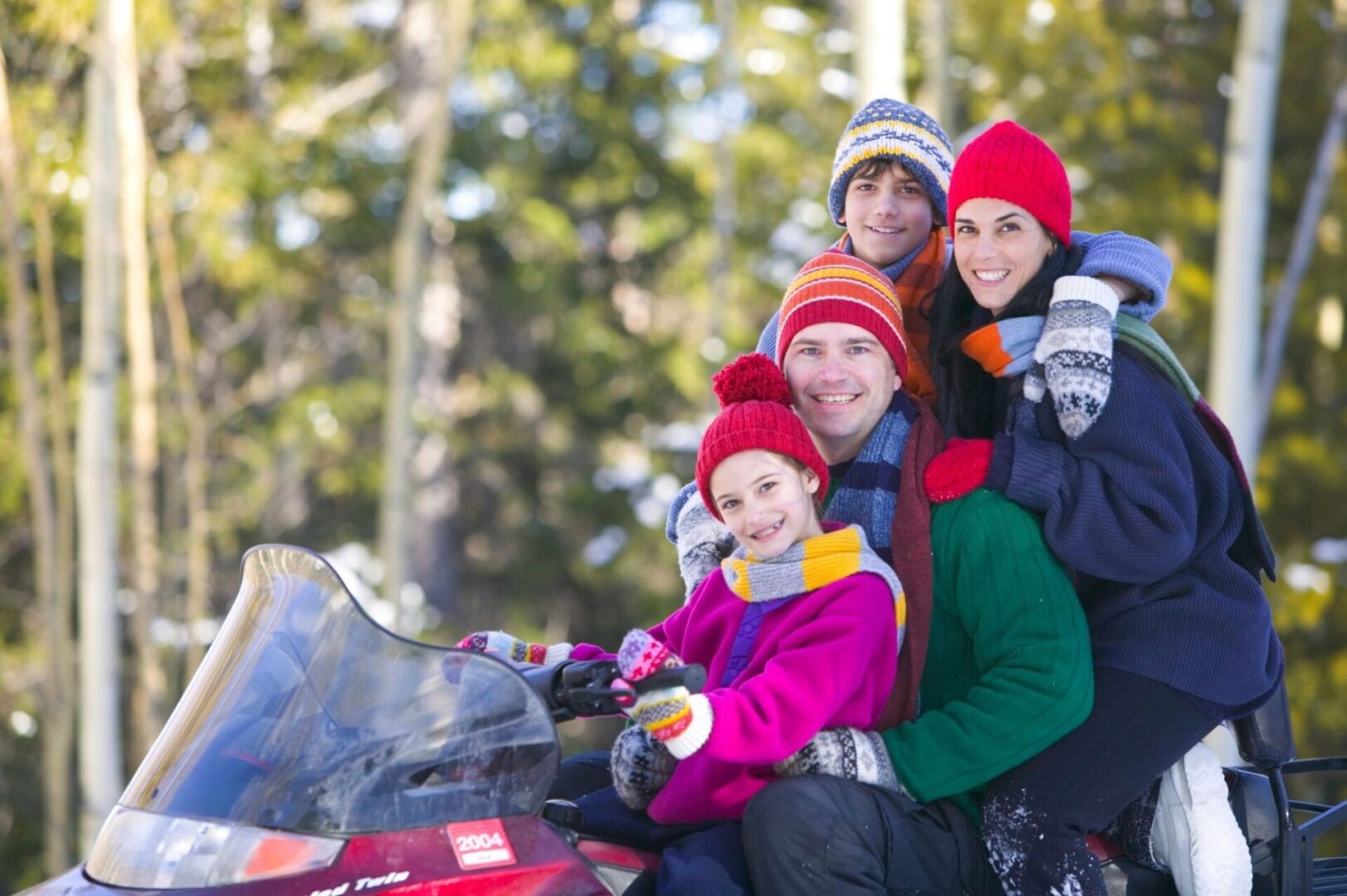 A group of people on a motorcycle in the snow.