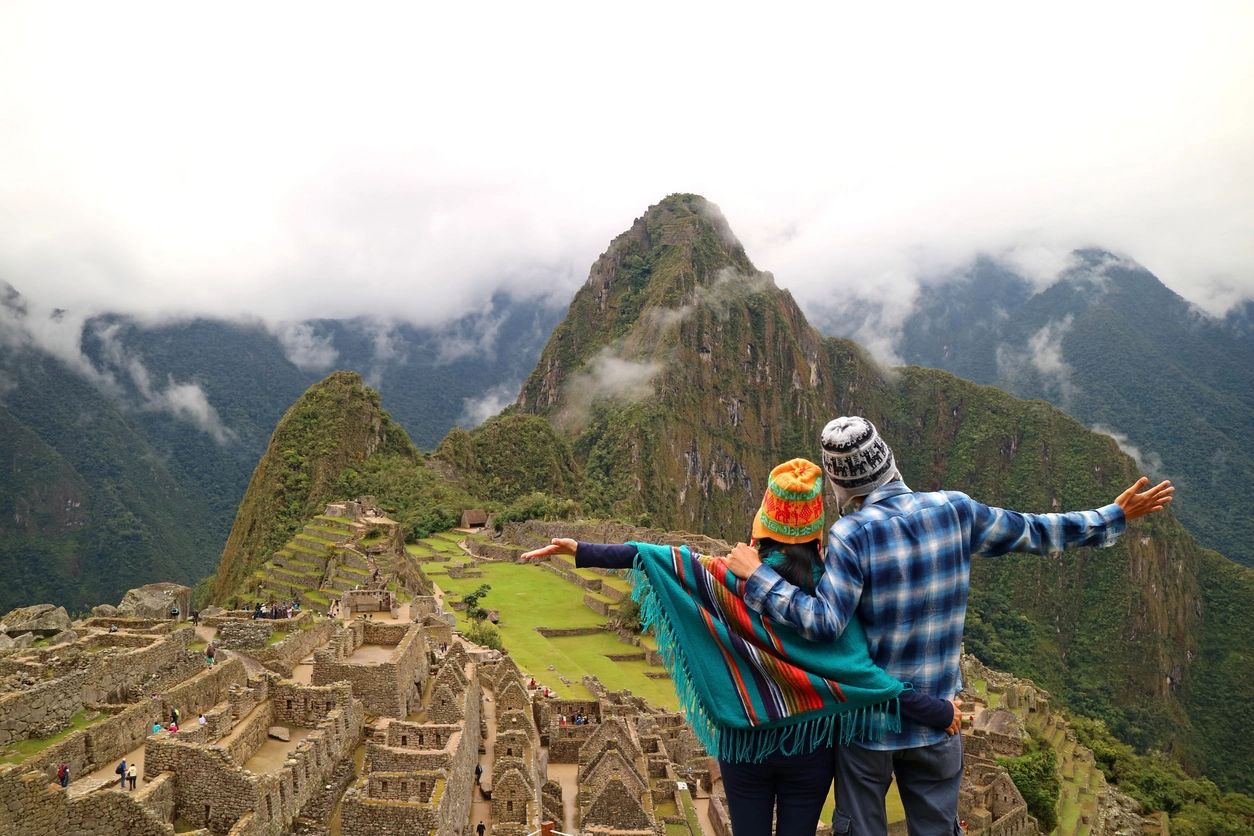 A man and woman standing on top of a hill.