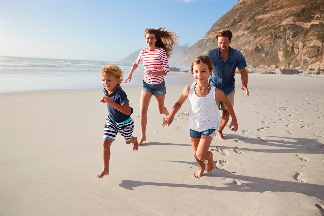 A family running on the beach with one child